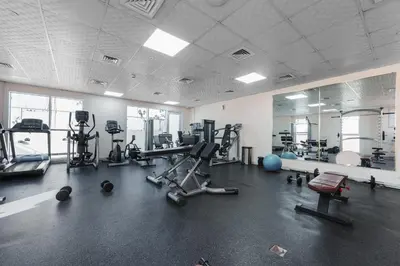 a gym with several machines and a mirror at Great Gatsby's Home in Dubai