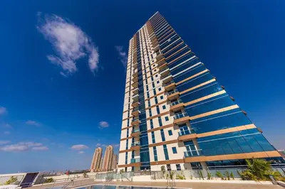 a tall building in front of a blue sky at Great Gatsby's Home in Dubai