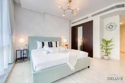 a bedroom with a white bed and a table at Upscale Studio at Sky Gardens DIFC by Deluxe Holiday Homes in Dubai