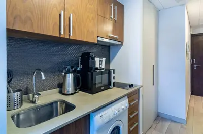 a kitchen with a sink and a washing machine at Silkhaus comfy furnished studio in the heart of DIFC in Dubai