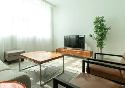 a living room with a tv and a table at RH-City Retreat, 01 BR, near Burj Khalifa Downtown in Dubai