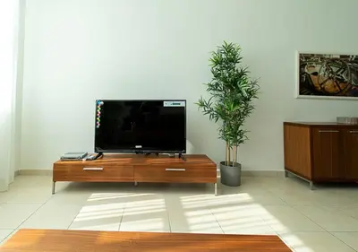 a flat screen tv sitting on top of a wooden entertainment center at RH-City Retreat, 01 BR, near Burj Khalifa Downtown in Dubai