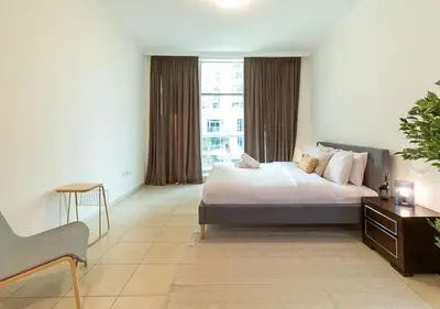 a bedroom with a bed and a large window at RH-City Retreat, 01 BR, near Burj Khalifa Downtown in Dubai