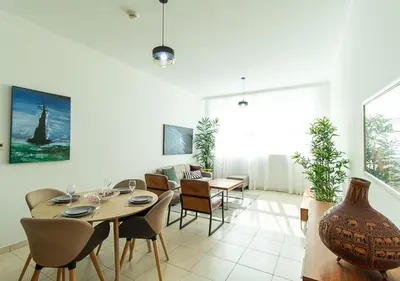 a dining room and living room with a table and chairs at RH-City Retreat, 01 BR, near Burj Khalifa Downtown in Dubai