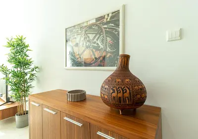 a vase sitting on top of a wooden cabinet at RH-City Retreat, 01 BR, near Burj Khalifa Downtown in Dubai