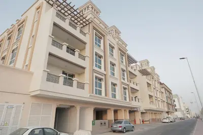 a large building with cars parked in front of it at Special Offer Studio for Rent in Dubai in Dubai