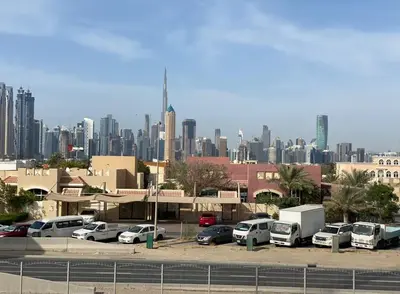 a parking lot with cars parked in front of a city at Special Offer Studio for Rent in Dubai in Dubai