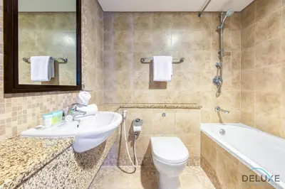 a bathroom with a sink and a toilet and a tub at Sleek Studio at Sky Gardens DIFC by Deluxe Holiday Homes in Dubai