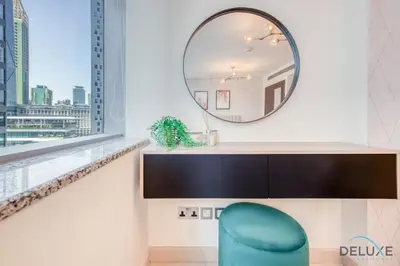 a mirror and a chair in a room with a window at Sleek Studio at Sky Gardens DIFC by Deluxe Holiday Homes in Dubai