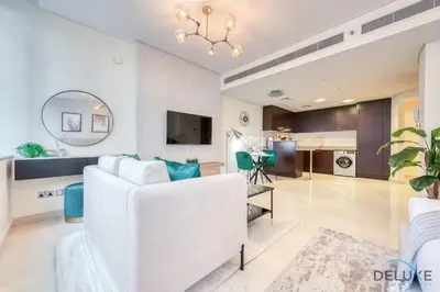 a living room with a white couch and a kitchen at Sleek Studio at Sky Gardens DIFC by Deluxe Holiday Homes in Dubai