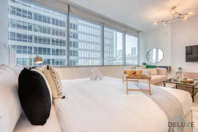 a large white bed in a room with a large window at Sleek Studio at Sky Gardens DIFC by Deluxe Holiday Homes in Dubai