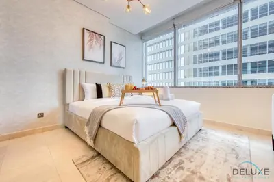 a bedroom with a bed with a table on it at Sleek Studio at Sky Gardens DIFC by Deluxe Holiday Homes in Dubai