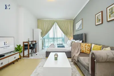 a living room with a couch and a tv at Luxury Escapes - Modern Studio near Metro in X1 Tower JLT in Dubai
