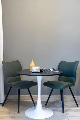 a table with two green chairs and a table with a lamp at Silkhaus Dubai Financial Center studio in Burj Daman in Dubai