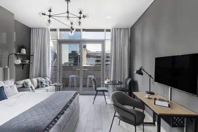 a bedroom with a bed and a desk and a tv at Silkhaus Dubai Financial Center studio in Burj Daman in Dubai