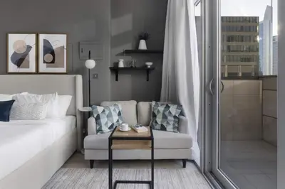 a living room with a couch and a chair and a shower at Silkhaus Dubai Financial Center studio in Burj Daman in Dubai