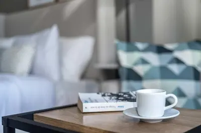 a coffee cup and a book on a table at Silkhaus Dubai Financial Center studio in Burj Daman in Dubai