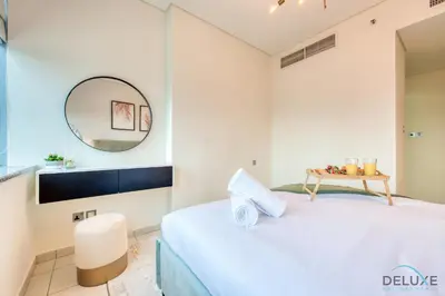 a bedroom with a bed and a mirror at Best Deal Elegant Studio with Balcony & Prime Location by Deluxe Holiday Homes in Dubai