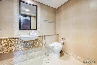 a bathroom with a toilet and a sink and a mirror at Best Deal Elegant Studio with Balcony & Prime Location by Deluxe Holiday Homes in Dubai