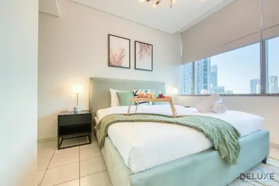 a bedroom with a bed and a large window at Best Deal Elegant Studio with Balcony & Prime Location by Deluxe Holiday Homes in Dubai