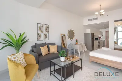 a living room with a couch and a table at Intimate Studio at Millennium Binghatti Residence Business Bay by Deluxe Holiday Homes in Dubai
