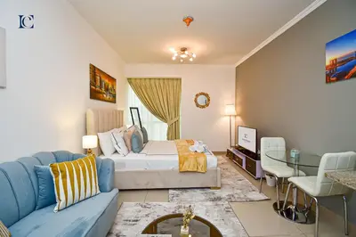 a bedroom with a bed and a blue couch at Luxury Escapes - Cozy Studio - Goldcrest Executives JLT in Dubai
