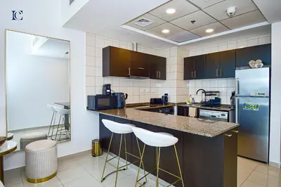 a kitchen with a counter and two bar stools at Luxury Escapes - Marina Views 1BR Apartments - Bay Central Dubai Marina in Dubai