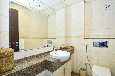 a bathroom with a sink and a toilet and a mirror at Luxury Escapes - Marina Views 1BR Apartments - Bay Central Dubai Marina in Dubai
