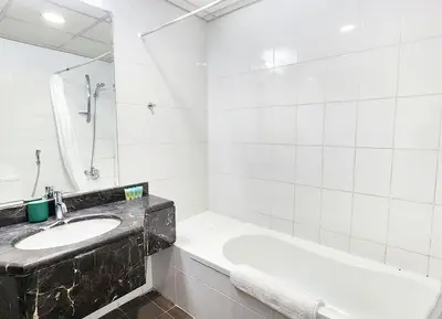 a white bathroom with a sink and a tub at RH- Urban Living, Studio near Dubai Mall, Downtown in Dubai