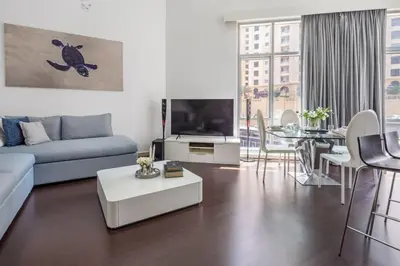 a living room with a couch and a table at Frank Porter - Marina Promenade in Dubai