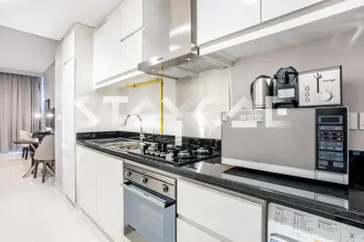 a kitchen with a stove and a microwave at Staycae Holiday Homes - Artesia in Dubai