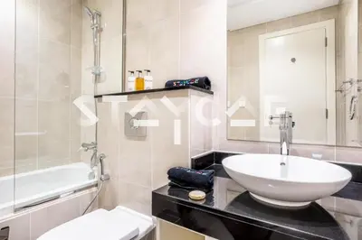 a bathroom with a sink and a toilet and a tub at Staycae Holiday Homes - Artesia in Dubai
