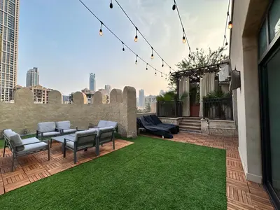 a rooftop patio with chairs and a green lawn at Durrani Homes - Unique Garden Apt at Souk Al Bahar besides Dubai Mall & Burjkhalifa with private jaccuzi in Dubai