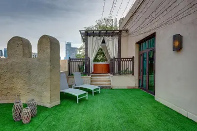 a patio with green grass and chairs on a building at Durrani Homes - Unique Garden Apt at Souk Al Bahar besides Dubai Mall & Burjkhalifa with private jaccuzi in Dubai