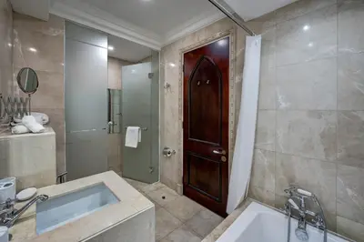 a bathroom with a sink and a wooden door at Durrani Homes - Unique Garden Apt at Souk Al Bahar besides Dubai Mall & Burjkhalifa with private jaccuzi in Dubai