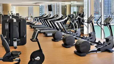 a gym with rows of treadmills and ellipticals at Marina Mall Apartments, Dubai Marina in Dubai