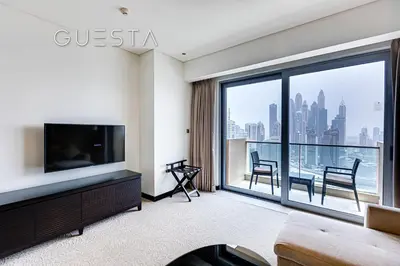 a living room with a tv and a large window at Marina Mall Apartments, Dubai Marina in Dubai