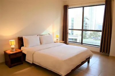 a bedroom with a white bed with a large window at Luxury Escapes - Large 1Bed with balcony and a great marina view in JBR in Dubai
