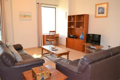 a living room with two leather couches and a television at Luxury Escapes - Large 1Bed with balcony and a great marina view in JBR in Dubai