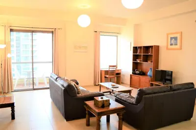 a living room with two couches and a tv at Luxury Escapes - Large 1Bed with balcony and a great marina view in JBR in Dubai