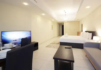 a large hotel room with a bed and a dining room at RH- Cozy Studio, Al Waleed , Cluster R, JLT in Dubai