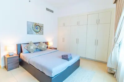 a bedroom with a bed and white cabinets at Luxury Escapes - Spacious 2BR Apt in the heart of Dubai Marina- Yacht Bay in Dubai