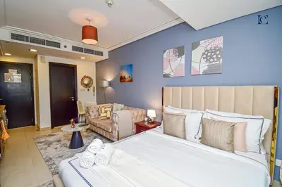 a bedroom with two beds and a living room at Luxury Escapes - Modern Studio Apt - Metro, Beach & Mall mins away in Dubai