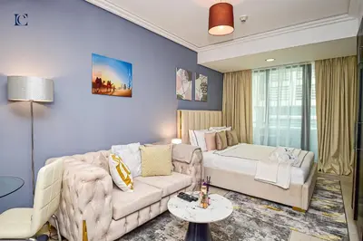 a living room with a couch and a bed at Luxury Escapes - Modern Studio Apt - Metro, Beach & Mall mins away in Dubai
