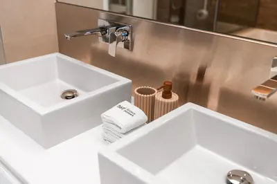 a bathroom with two white sinks and a mirror at Most beautiful 3 BR apt in BLUEWATERS ISLAND, DUBAI in Dubai