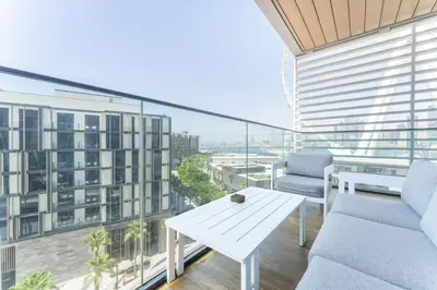 a living room with a table and chairs on a balcony at Most beautiful 3 BR apt in BLUEWATERS ISLAND, DUBAI in Dubai