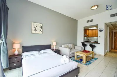 a bedroom with a bed and a living room at Luxury Escapes - Tranquil Studio Near Furjan Metro - Relaxing Holiday Retreat in Dubai