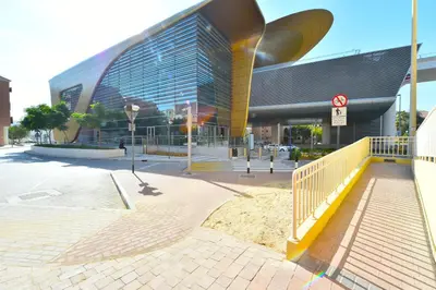 a large building with a yellow fence in front of it at Luxury Escapes - Spacious Fully Furnished Studio Apt - Next to Metro, 5 Mins from Mall - MED46 in Dubai