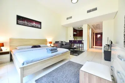 a bedroom with a bed and a living room at Luxury Escapes - Spacious Fully Furnished Studio Apt - Next to Metro, 5 Mins from Mall - MED46 in Dubai