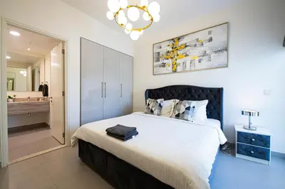 a bedroom with a large bed and a bathroom at Modern Dubai Hills Luxury 4 BEDROOM VILLA in Dubai